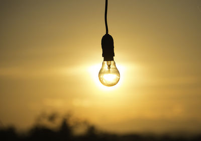 Low angle view of silhouette lamp against sky during sunset