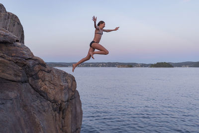 Girl jumping into sea