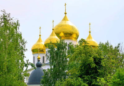 Golden cupola of russian orthodox church among green trees