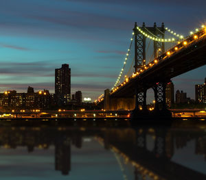 Illuminated bridge over river at night