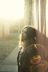 Young woman looking down while standing outdoors