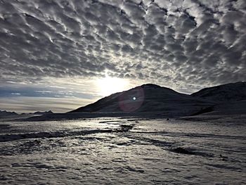 Scenic view of mountains against cloudy sky