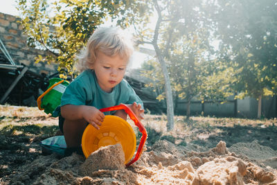 Boy playing with sand in yard