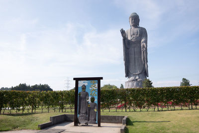 Statue on field against sky