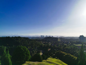 Panoramic view of trees and cityscape against sky