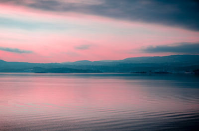 Scenic view of lake against romantic sky at sunset