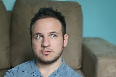 Portrait of young man relaxing on sofa at home