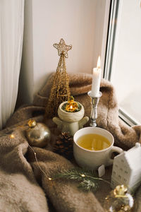 Hot tea, candles, christmas golden balls and decorations. christmas holiday mood.