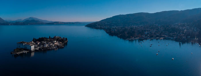 Panoramic view of sea and mountains against clear blue sky