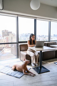 Rear view of woman sitting on table at home