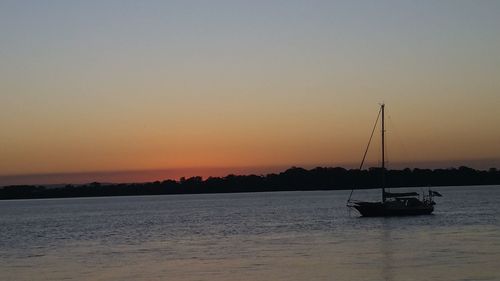 Boats in sea at sunset