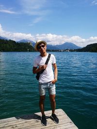 Full length man standing on pier over lake against sky