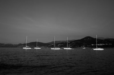 Sailboats in sea against sky