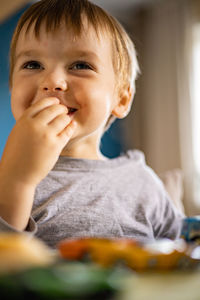 Portrait of cute boy eating at home