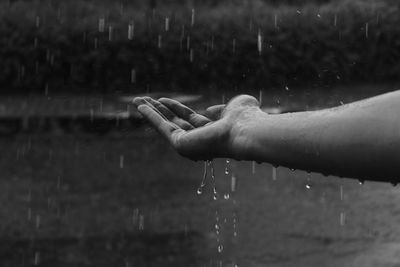 Cropped image of man holding raindrops