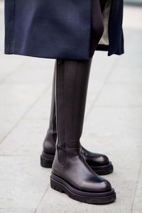 Close-up of legs in over knee high black leather boots. fashion details trend fashionable woman