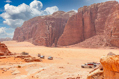 Orange sands and rocks of wadi rum desert with bedouin cars in the foreground, jordan