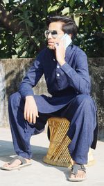 Full length of young woman sitting on bench