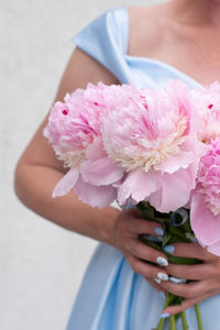 Bride in a blue wedding dress with a bouquet of pink peonies, pastel paradise