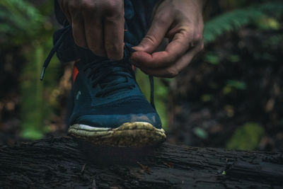 Low section of man tying shoes