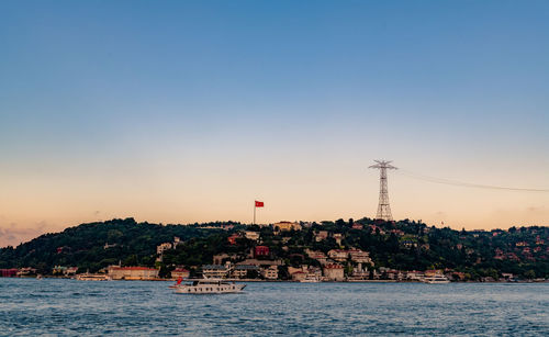 River by buildings against sky during sunset