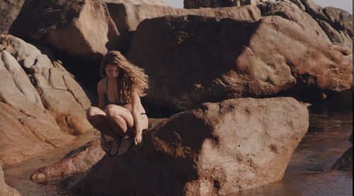 Woman sitting on rock formation