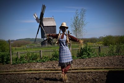 Full length of woman with umbrella on field