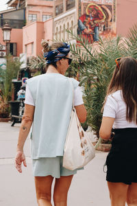 Rear view of two women standing in city