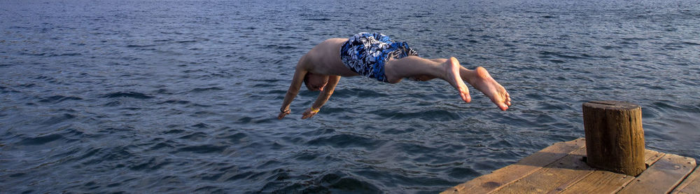 Side view of man diving into lake