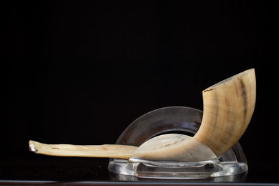 Close-up of bread in bowl on table against black background