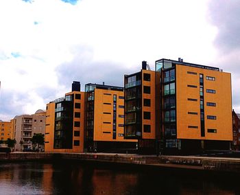 Buildings in city against cloudy sky