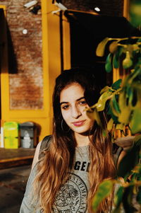 Portrait of smiling beautiful woman by plants