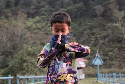 Boy posing in karate against mountain