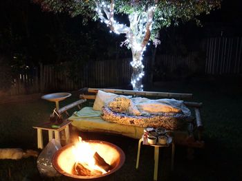 Lit candles on barbecue grill in yard