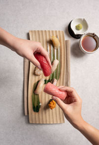 Cropped hand of person holding food on table