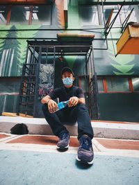 Full length of man sitting outdoors