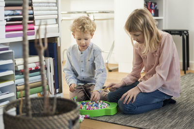 Siblings playing magnet fishing at home