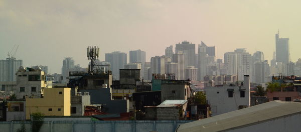 Buildings in city against clear sky