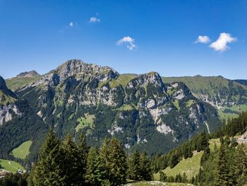 Scenic view of mountains against blue sky