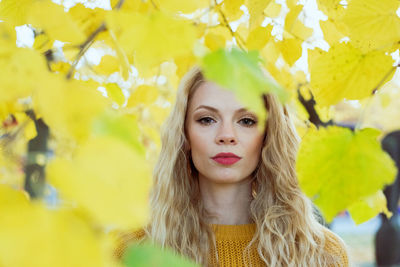 Portrait of young woman with yellow leaves