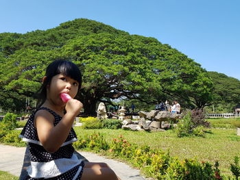 Portrait of beautiful young woman on land against sky