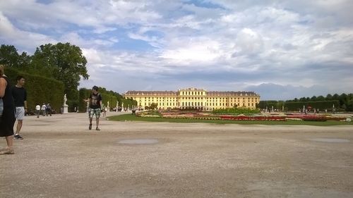 People in park by building against sky