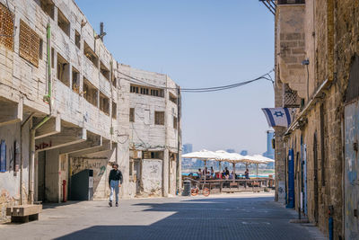 People walking on street amidst buildings in city