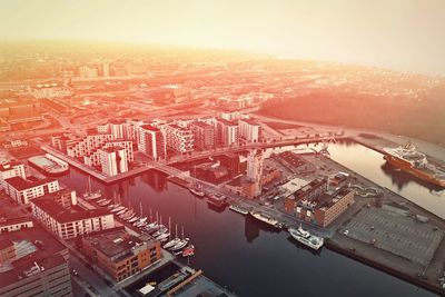 High angle view of river by buildings against sky during sunset