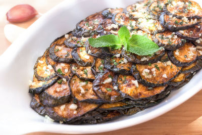 Close-up of fried zucchini slices in plate served on table