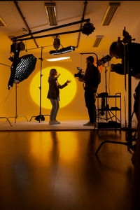 Rear view of man playing guitar on stage