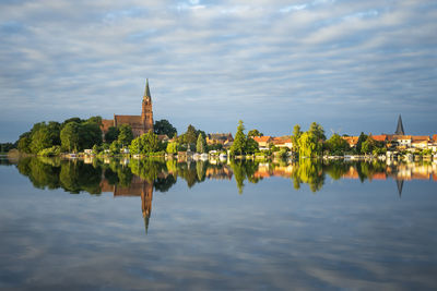 Panoramic view of lake by building against sky