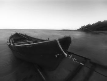 Boat moored on sea against clear sky