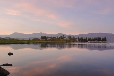 Scenic view of lake against sky at sunset