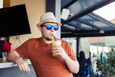 Midsection of man holding drink drinking glass